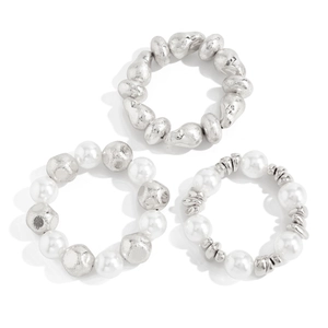 Detailed view of three elastic bracelets with silver irregular beads and white faux pearls