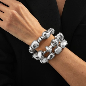 Macro shot of silver textured beaded stretch bracelets with organic lava-style shapes