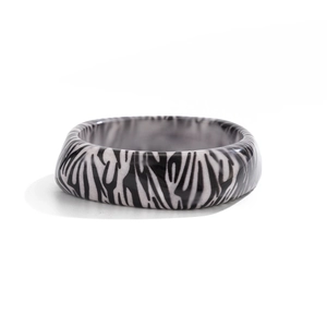 Vue détaillée d'une large bague en résine avec motif zébré noir et blanc au fini brillant