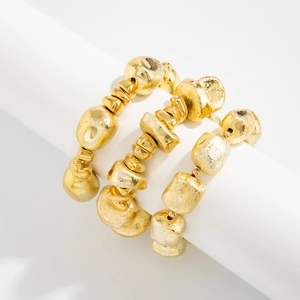 Macro detail of three gold resin stretch bracelets with textured matte pebble beads