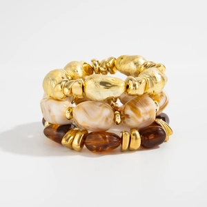 Detail of stacked stretch bracelets with gold metallic beads and marble resin textures