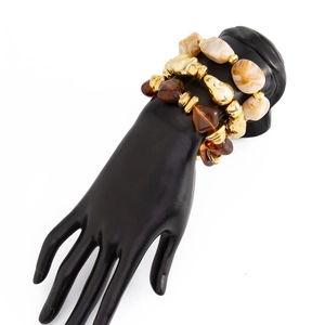 Close-up of bohemian beaded bracelet set featuring marble, amber resin, and gold metal beads