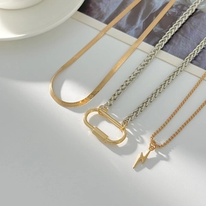 Mix and match layered gold snake chains and lightning bolt pendants with a carabiner lock