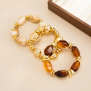 Detail view of a 3-piece stretch bracelet set with resin marble beads and gold geometric accents