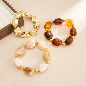 Detailed close-up of retro beaded elastic bracelets with golden CCB beads and resin textures