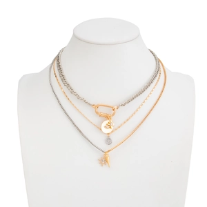 Detail of layered gold and silver necklace featuring star pendants and link chain