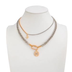 Detail of layered curb chain necklace with carabiner clasp and star pendant