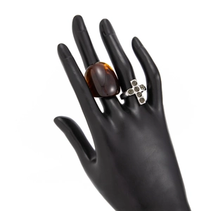 Detail of vintage silver rings with amber resin stone and micro-pave cross on black hand