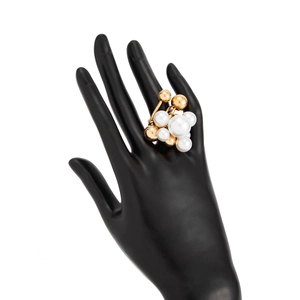 Modern geometric ring featuring gold beads and white pearls on a black hand model