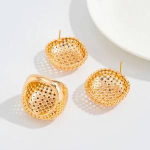 Dettaglio di un set di gioielli d'oro con anello e orecchini in maglia intrecciata cava