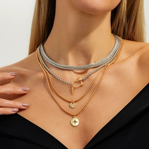 Detail of layered hip-hop necklaces with U-shaped buckles and star compass pendants