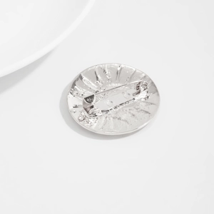 Dettaglio macro del retro della spilla d'argento con chiusura di sicurezza e finitura metallica