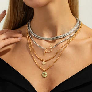 Detail of layered gold and silver starburst pendant necklaces with U-shaped hook