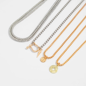 Detail view of four trendy layered necklaces with star and U-shaped pendant designs