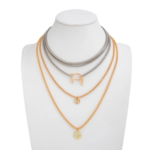 Close-up of triple-layered necklaces with silver braided chain and compass pendants