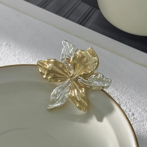 Dettaglio della spilla a fiore artistica con petali martellati bicolore in oro e argento