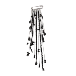 Detail of safety pin brooch with multi-layered black beads and silver tassel chains