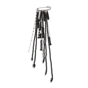 Detail of silver safety pin brooch with hanging black beaded tassels and metal chains