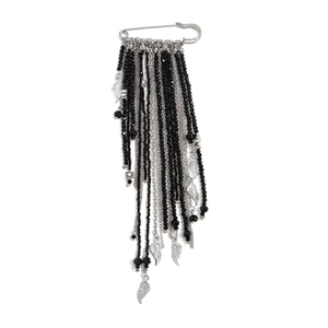 Detailed close-up of gothic silver safety pin brooch with black beaded fringe and wings