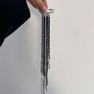 Détail de la broche épingle à nourrice créative avec longues franges de perles noires et argent