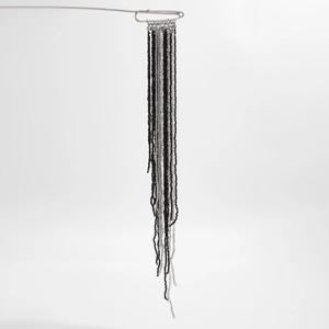 Détail de la broche à franges perlées avec cristaux noirs et argentés et fermoir épingle