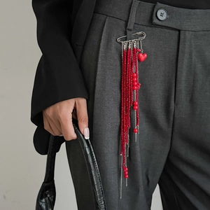 Vue détaillée d'une broche épingle à nourrice argentée avec perles rouges et pendentif cœur
