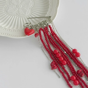 Fashionable red beaded tassel brooch with heart pendant and silver safety pin detail