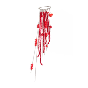 Detail of red bead tassel safety pin brooch with hanging silver chains and heart charm