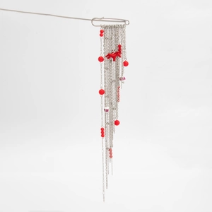 Détail de la broche à pampilles argentées avec perles rouges et pendentif de cheval
