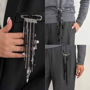 Broche pompon punk rétro avec chaînes argentées et perles noires sur un blazer