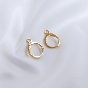 Détail de crochets d'oreilles 14K plaqués or sur tissu satin blanc pour DIY