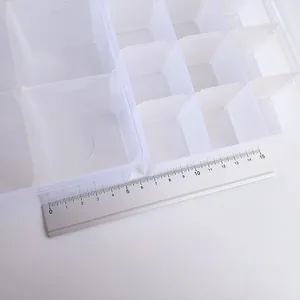 Macro view of clear plastic storage box with ruler showing the grid size measurements