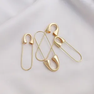 Detailed view of polished 14K gold plated safety pins in multiple sizes for DIY jewelry