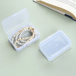 Macro detail of a 9x6x3cm transparent plastic storage box showing lid and jewelry