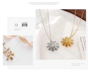 Close-up of gold and silver daisy flower pendants with textured petals on fine chains