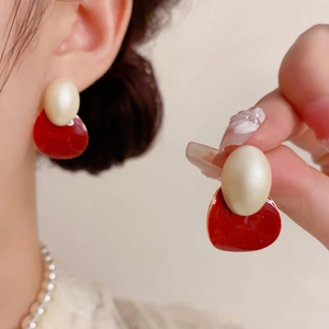 Boucles d'oreilles ovales vintage avec perle crème et émail rouge sur modèle