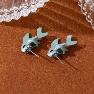 Gros plan de boucles d'oreilles requin gris-vert avec un design unique en deux parties