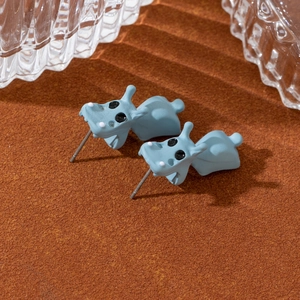Vue macro de boucles d'oreilles hippopotame bleu avec design en deux parties sur fond orange