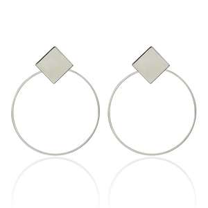 Detail of silver geometric earrings featuring square studs and large round thin frames