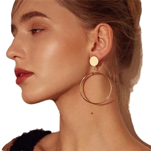 Minimalist gold hoop earrings for women featuring a polished metallic geometric circle design