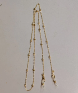 Détail d'une chaîne de lunettes dorée avec perles décoratives et boucles en silicone