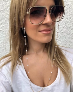 Chaîne à lunettes dorée avec perles blanches sur mannequin, cordon de lunettes chic
