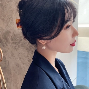 Boucles d'oreilles perles et pince à cheveux écaille portées par un mannequin femme