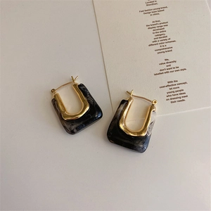 U-shaped earrings with gold metal and marble texture resin on minimalist card
