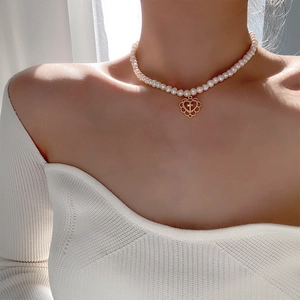 Collier de perles vintage avec pendentif cœur ajouré doré et croix sur mannequin
