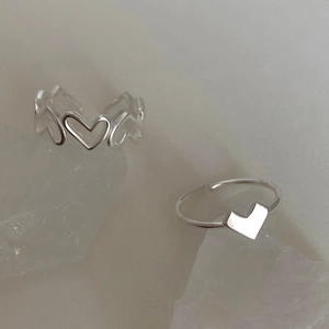 Elegant hollow heart silver rings displayed on crystals with a minimalist design