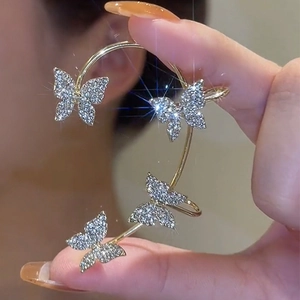 Orecchino a morsetto con farfalle scintillanti e cristalli su base dorata elegante
