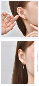 Detail view of gold chain drop earrings on model showcasing elegant vertical design