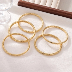 5-piece set of minimalist gold elastic bangles with twisted and hammered metal textures