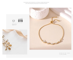 Detalle de pulsera ajustable de titanio dorado con cinco piedras de circonita de marquesa